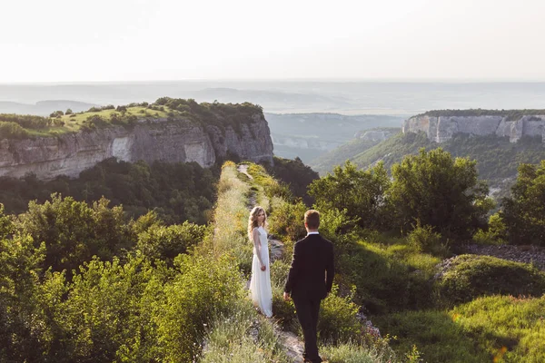 Esküvői pár sétál a hegy szélén — Stock Fotó