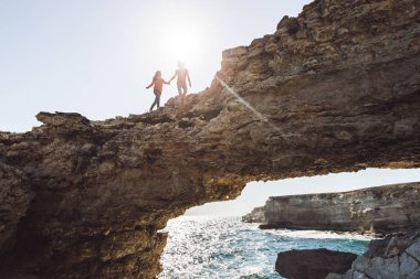 kayalık sahilin yanında çalışan çift