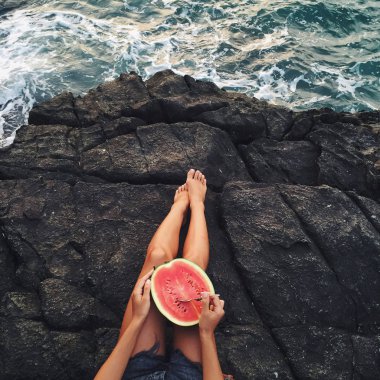 Woman eating watermelon on beach clipart