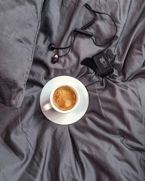 Кава в ліжку і фітнес трекер — стокове фото