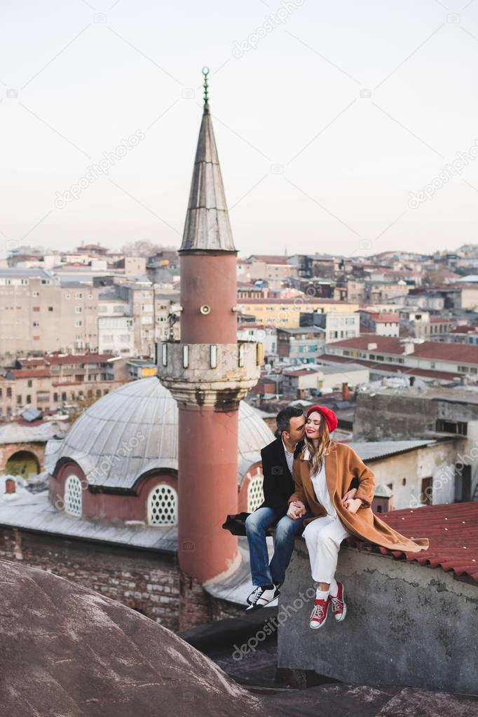Couple in love sitting  on roof 