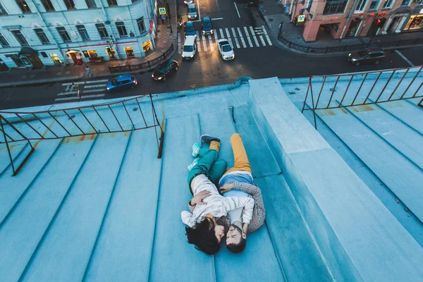 年轻的时髦夫妇躺在屋顶上 — 图库照片