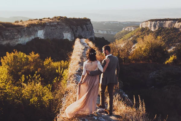 Жених и невеста гуляют по горам — стоковое фото