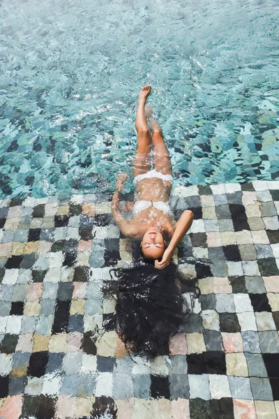 Vrouw ontspannen in luxe zwembad — Stockfoto