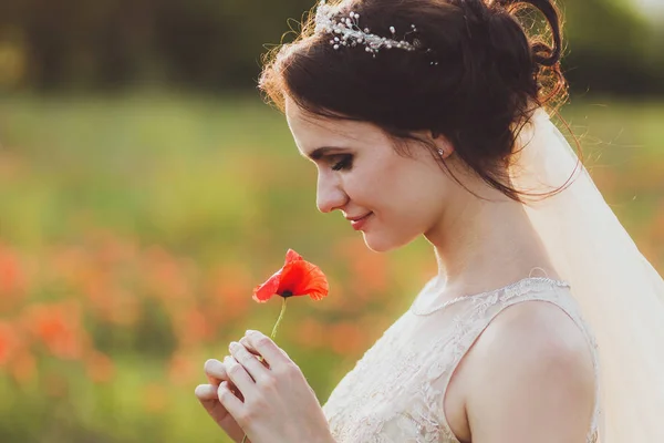 Невеста держит цветок мака — стоковое фото
