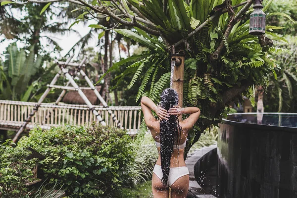 Donna che si fa la doccia nel giardino tropicale — Foto Stock