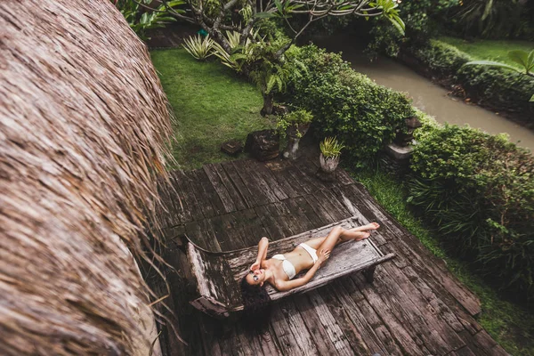 Женщина отдыхает на деревянном шезлонге — стоковое фото
