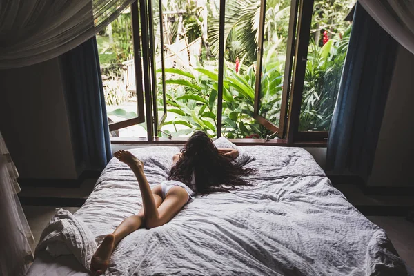 Mujer en lencería blanca descansando en la cama —  Fotos de Stock