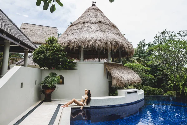 Mulher relaxante por piscina em Bali tropical — Fotografia de Stock