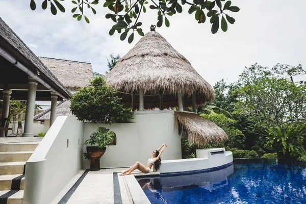 Mulher relaxante por piscina em Bali tropical — Fotografia de Stock