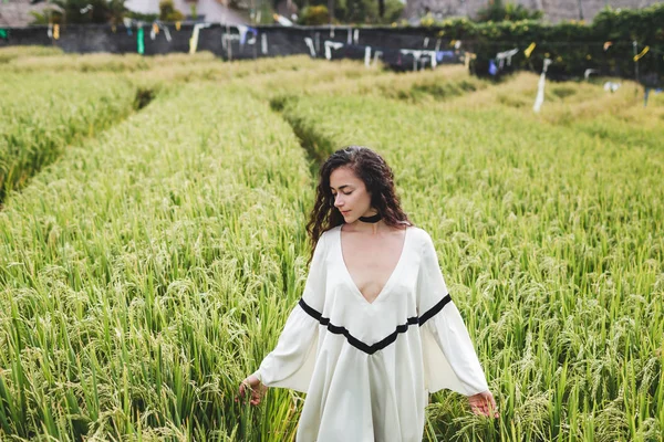 woman in white tunic in rice field