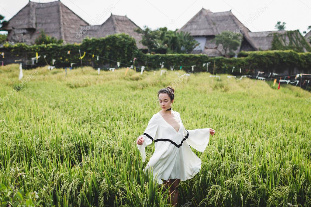 woman in white tunic in rice field 