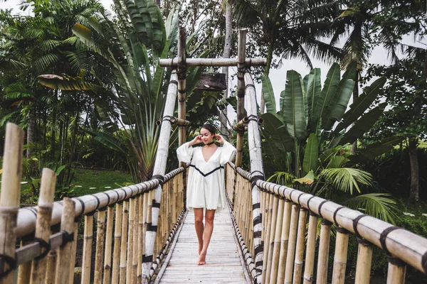 Girl walking on suspension bamboo bridge — Stock Photo, Image