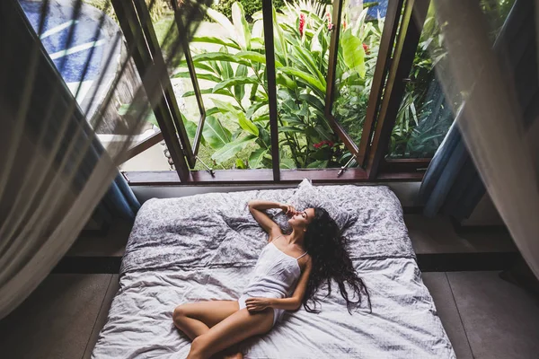 Женщина в нижнем белье лежит в постели — стоковое фото