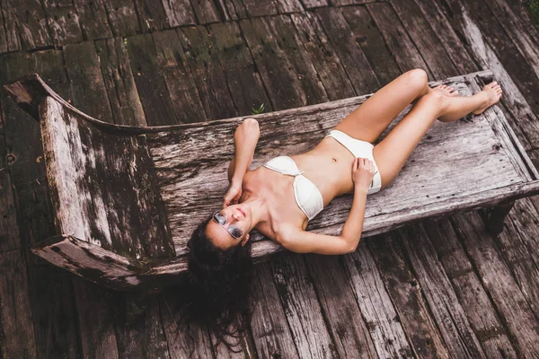 Kobieta relaksujący na drewniane szezlong — Zdjęcie stockowe