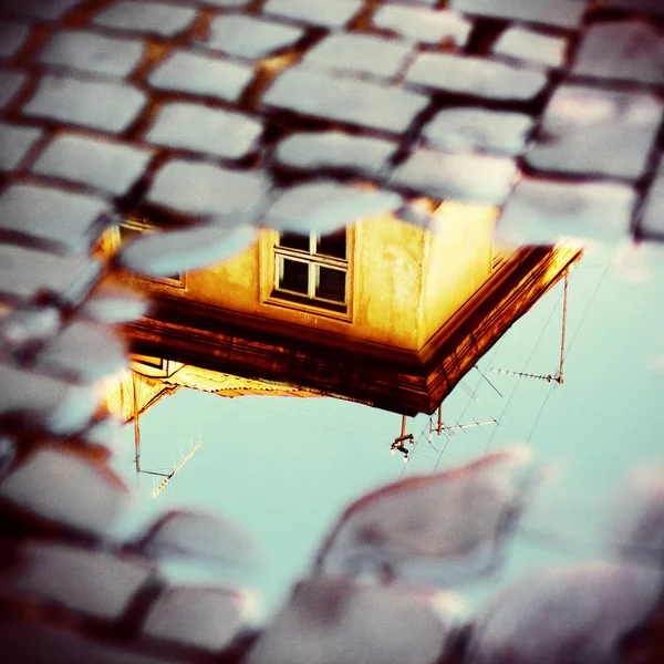 Old yellow house in puddle reflection — Stock Photo, Image