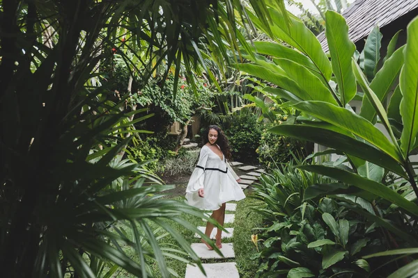 Mulher caminhando no jardim tropical — Fotografia de Stock