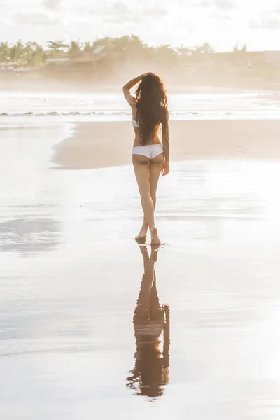 Vrouw die op het strand loopt — Stockfoto