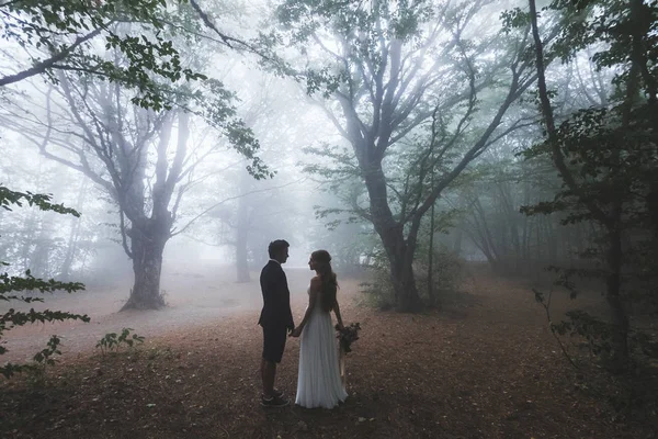 Sposa e sposo a piedi nella foresta autunnale — Foto Stock