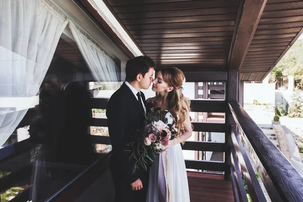 Bruidegom kuste bruid op balkon — Stockfoto