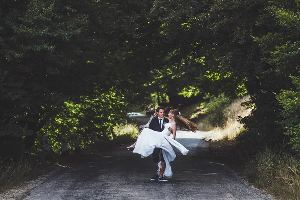 Sposo che tiene sposa sulle mani — Foto Stock