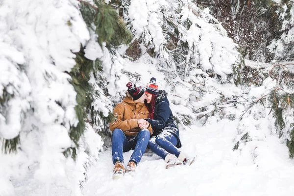 Пара веселится и бросает снег в зимнем лесу — стоковое фото