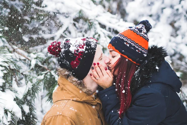 Пара веселится и бросает снег в зимнем лесу — стоковое фото