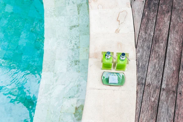 Bottiglie di shampoo su orlo di piscina — Foto Stock