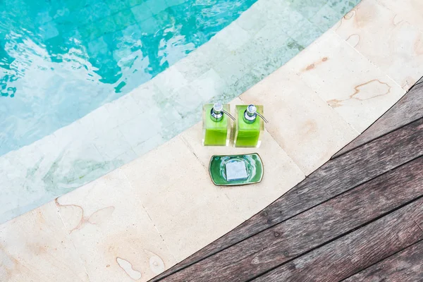 Flaschen Shampoo und handgemachte Seife am Pool — Stockfoto