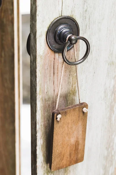 金属製のドアのノブに掛かっているバリ風の木製看板 — ストック写真