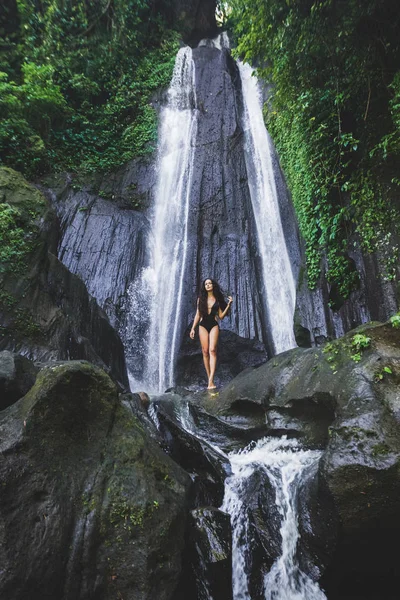 Kvinna nära gömd i djungeln kaskad vattenfall — Stockfoto