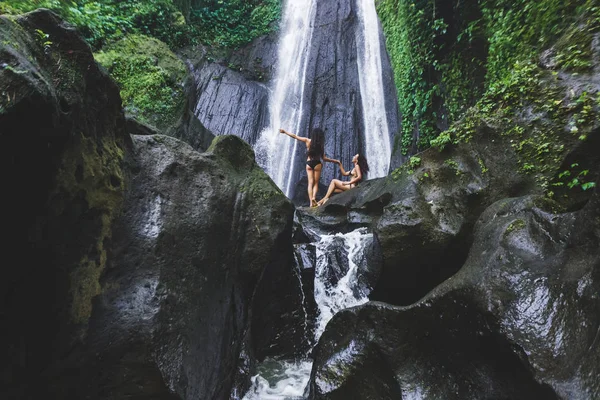 Two slim women near beautiful waterfall — Stock Photo, Image