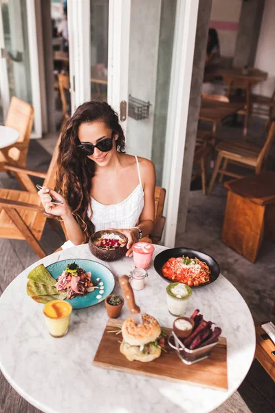 Jovem sorrindo mulher tomando café da manhã — Fotografia de Stock