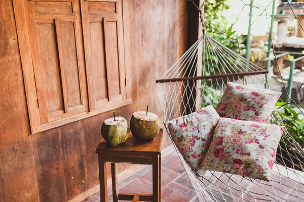 Hangmat Met Kleurrijke Kussens Houten Tafel Met Twee Verse Kokosnoten — Stockfoto