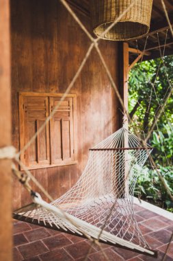 Hamak hipster ahşap evde asılı. Relax, tropikal ruh hali için yer