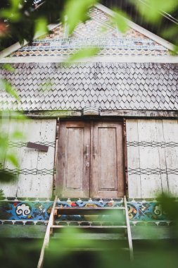 Kiremit çatılı, eski ahşap geleneksel ev süsleme ile duvarlar boyalı ve Panjur kapı kapalı