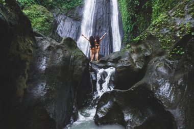 İki ince kadın Bali ormanda güzel şelale yakınındaki rahatlatıcı. Doğa macera Dusun Kuning Ubud bölgesinde