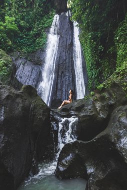 Kadının yakın orman basamaklı şelale Bali gizli. İnce gövde ve siyah mayo, moda modeli. Dusun Kuning Ubud bölgesinde