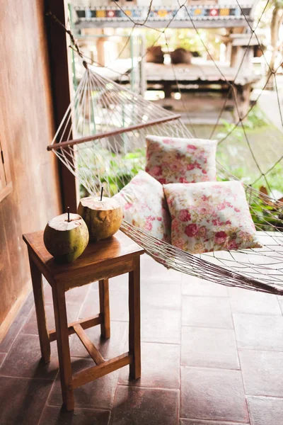 Hangmat Met Kleurrijke Kussens Houten Tafel Met Twee Verse Kokosnoten — Stockfoto