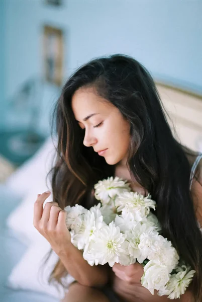 Утренний портрет юной брюнетки с буком белых цветов — стоковое фото