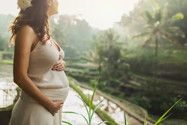 Bali pirinç tarlası manzaralı beyaz elbiseli genç hamile kadın. — Stok fotoğraf