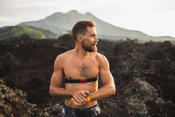 Homme athlétique commencer à exécuter le programme sur la montre intelligente ou fitness tra — Photo