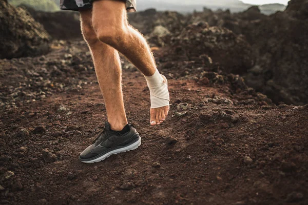 Tobillo de hombre con vendaje de compresión. Lesión en la pierna mientras trail runni — Foto de Stock