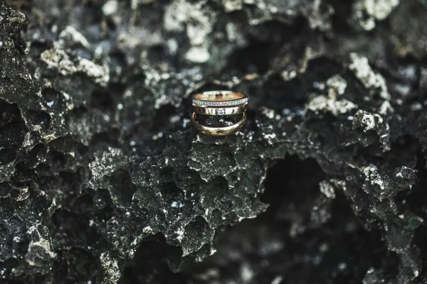 Τρία δαχτυλίδια γάμου και πρότασης γάμου με πολύτιμους λίθους σε πέτρα μαύρο t — Φωτογραφία Αρχείου