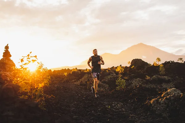Young male athlete trail running in mountains at sunrise. Amazin — Stock Photo, Image