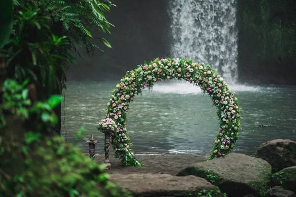 Ceremonia de boda en la cascada de Tibumana, Bali. Arco redondo con fr — Foto de Stock