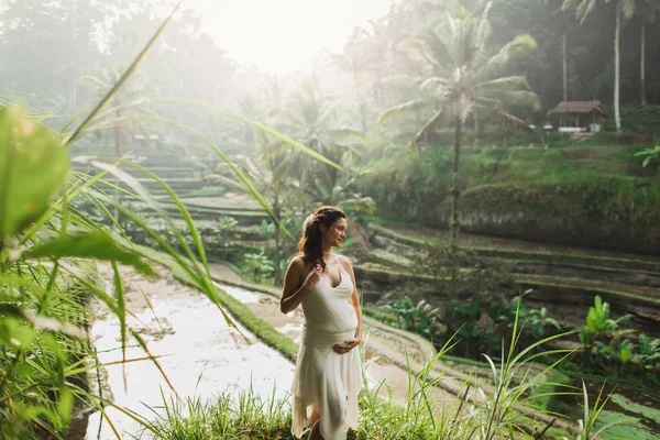 Giovane donna incinta in abito bianco con vista su Bali riso terra — Foto Stock