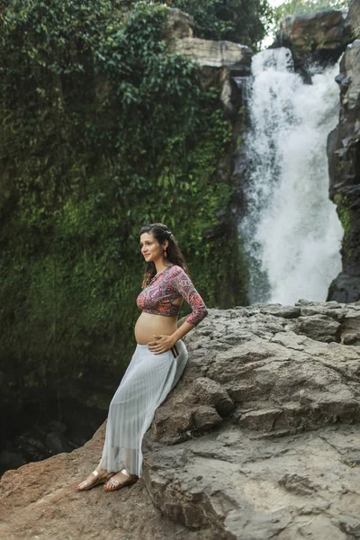 Jovem mulher grávida autêntica perto de cachoeira cascata incrível. N — Fotografia de Stock