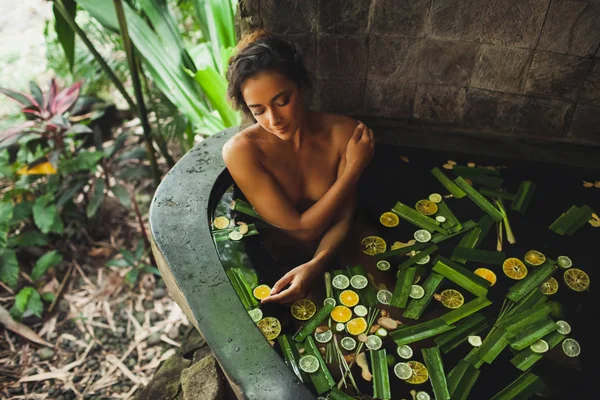 Красива молода жінка насолоджується відпочинком на відкритому повітрі. Розкішна кам'яна ванна — стокове фото