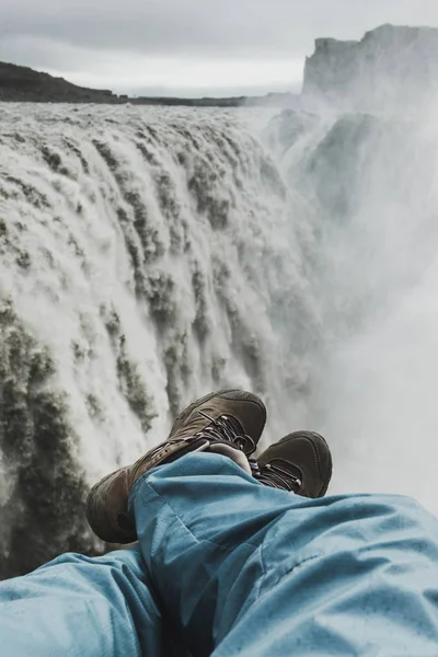 Pés em sapatos de trekking com vista para a cachoeira Dettifoss em Icela — Fotografia de Stock